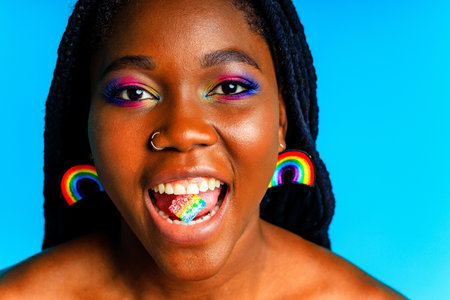 young woman wearing colorful blouse standing isolated over blue background, lgbt conceptの写真素材