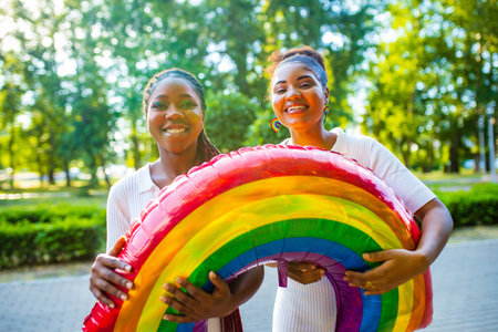 african american couple of two young beautyful women in summer parkの写真素材