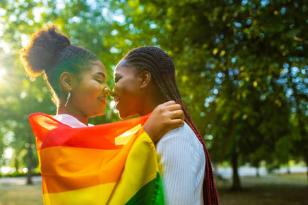 happy african american one gender couple in love dating outdoors in summer parkの写真素材