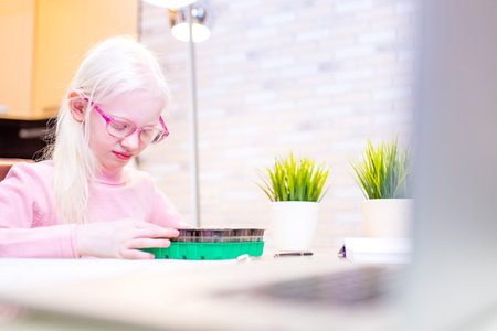 child putting a seed to plant in a seed growing tray at homeの写真素材