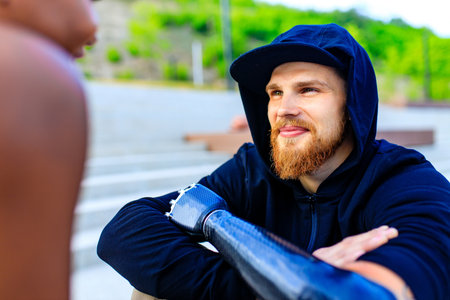 man with arm prosthesis in sports clothing ready for morning workout outdoors. Disabled sport...