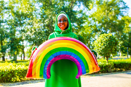 african woman in green hijab with bright makeup with rainbow air balloon in summer park outdoorの写真素材