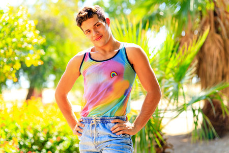 Handsome man in colorful shirt with rainbow badge outdoorの写真素材