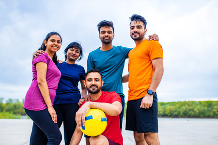 four indian people warming up outdoors in sport wear morning time urbanの写真素材
