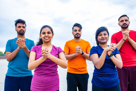 four indian people warming up outdoors in sport wear morning time urbanの写真素材