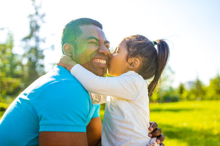 fathers day celebration happy afro american man with his cute baby in summer park having fun togetherの写真素材
