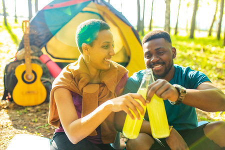 two happy african american people in love spending time outdoors in campの写真素材