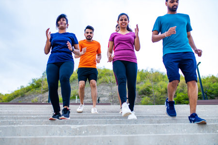 four indian people warming up outdoors in sport wear morning time urbanの写真素材