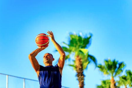 turkish man playing basket ball outdoor in summer day blue sky backgroundの写真素材