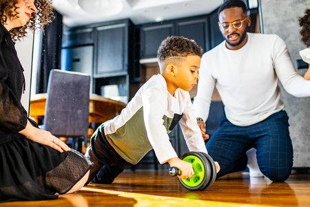 african mulatto family working out at home with children exercises with Ab Wheel abs