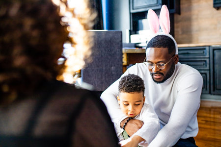 multicultural hispanic family wearing rabbit ears in living room soft sun day lightの写真素材