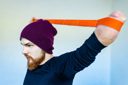 disabled man doing exercises with rubber at home stay positive and strongの写真素材