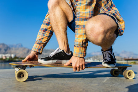close up photo of man skateboarding near river at sunny summer dayの写真素材