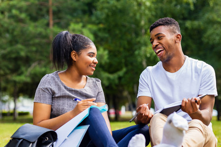 afro american friends sharing knowledge in the university campus at sunny day outdoors in parkの写真素材