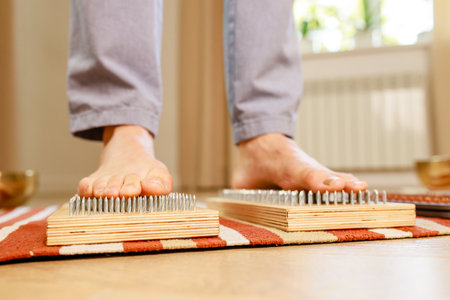 morning yoga practice with sadhu nails. mans foot on the wooden desk with sharp metal nailsの写真素材