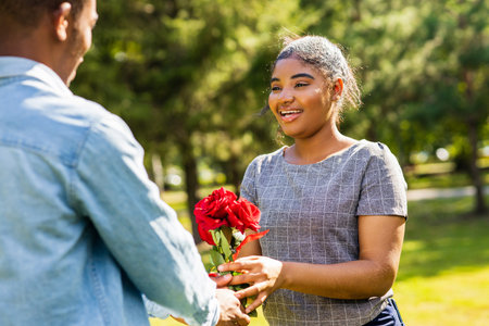 Smiling african couple at romantic picnic in summer park dation at sunny dayの写真素材