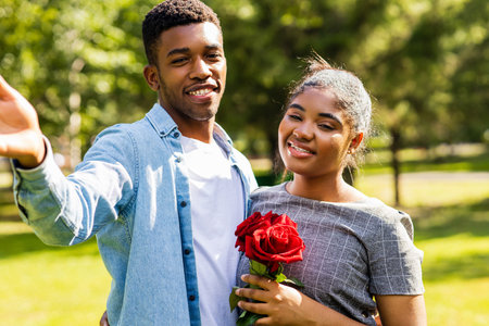 Smiling african couple at romantic picnic in summer park dation at sunny dayの写真素材