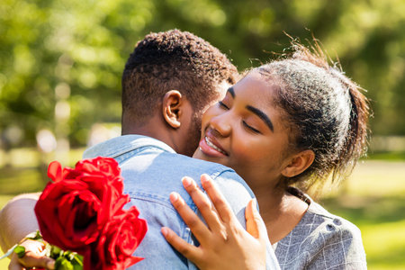Smiling african couple at romantic picnic in summer park dation at sunny dayの写真素材