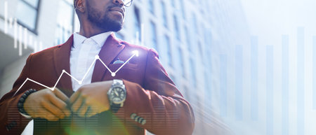 A man in a suit is wearing a watch and looking at a graphの写真素材