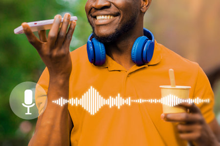 A man is holding a cell phone and wearing headphones