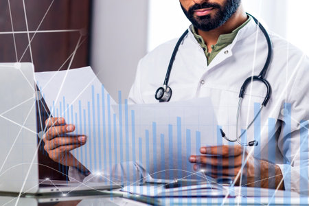 A doctor is looking at a computer screen with a graph on itの写真素材
