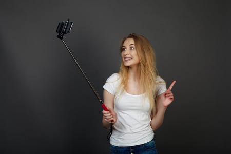 young pretty blonde women taking selfie on cell phone in studio