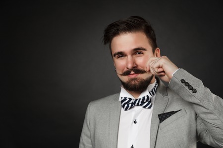 handsome guy with beard and mustache in suit on dark backgroundの写真素材