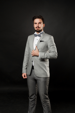 handsome guy with beard and mustache in suit on dark backgroundの写真素材