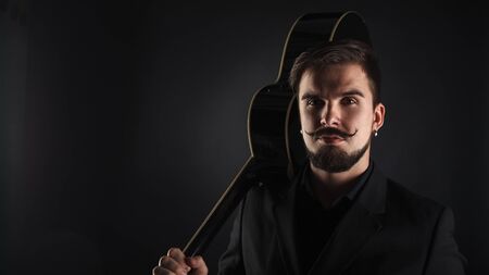 handsome brutal guy with beard on dark background in studioの写真素材