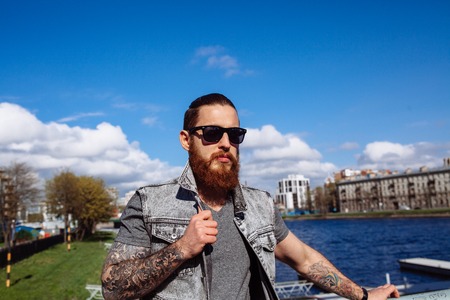 Bearded hipster wearing sunglasses in the city outdoorの写真素材