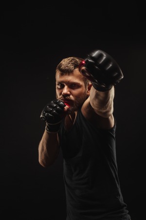 Athletic bearded boxer with gloves isolated on a dark backgroundの写真素材