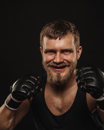 Athletic bearded boxer with gloves isolated on a dark backgroundの写真素材