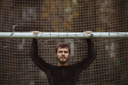 Male athlete resting on soccer field urban viewの写真素材