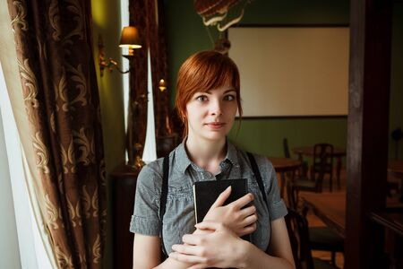 Beautiful female student in a university library having funの写真素材