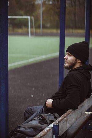 Muscular male athlete taking break standing relaxing after training outdoorsの写真素材