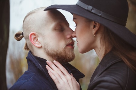 kissing couple of hipsters in fall parkの写真素材