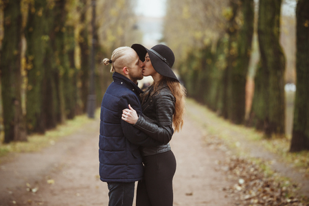 girlfriend and boyfriend kiss in fall park with perspectiveの写真素材