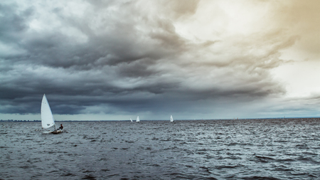 old sail boat in the ocean and cloudsの写真素材