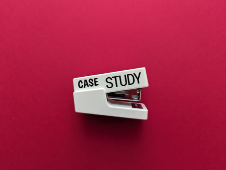 Case study text on a white stapler with red isolated background.の写真素材
