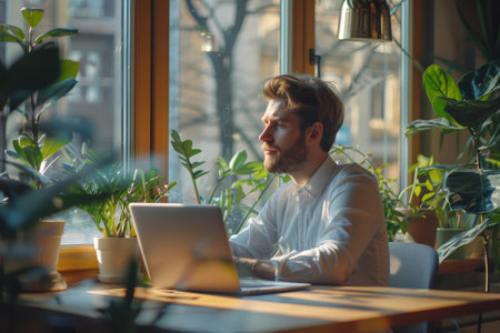Casual business man working on laptop in modern office space.の素材