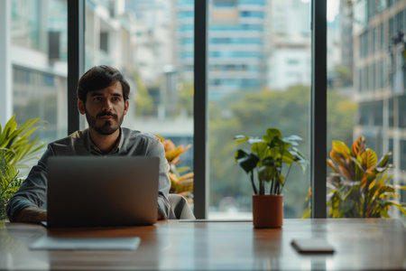 Casual business man working on laptop in modern office space.の素材