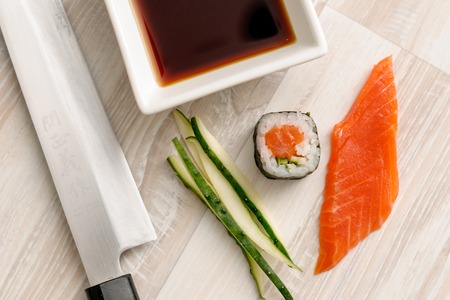 sushi rolls with ingredients on the wooden board