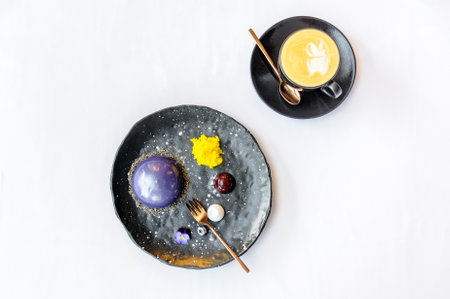 Space dessert on a black plate and a cup of coffee