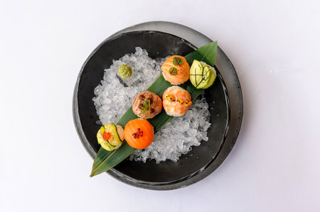 Temari sushi on a black plate with iceの写真素材