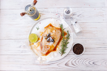 Fresh squid. Raw squid with spices and herbs ingredients for cooking on white wooden background. Top view.の写真素材