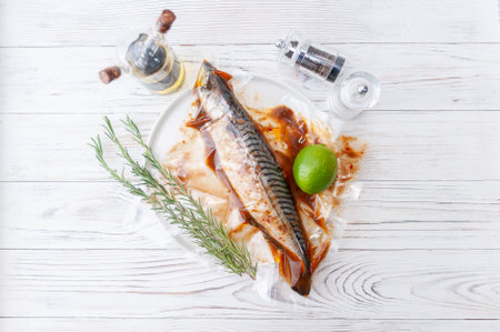 Fresh fish mackerel. Raw fish mackerel with spices and herbs ingredients for cooking on white wooden background. Top view.の写真素材