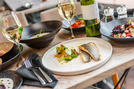 Dorado or sea bass fillet in cream sauce with broccoli on a white plate. High quality photoの写真素材