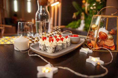 Sushi roll with cream cheese, sesame seeds and caviar on a plate close-up in a festive holiday settingの写真素材