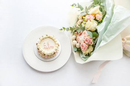 Festive bento cake and bouquet on a light backgroundの写真素材