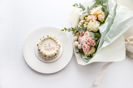 Festive bento cake and bouquet on a light backgroundの写真素材